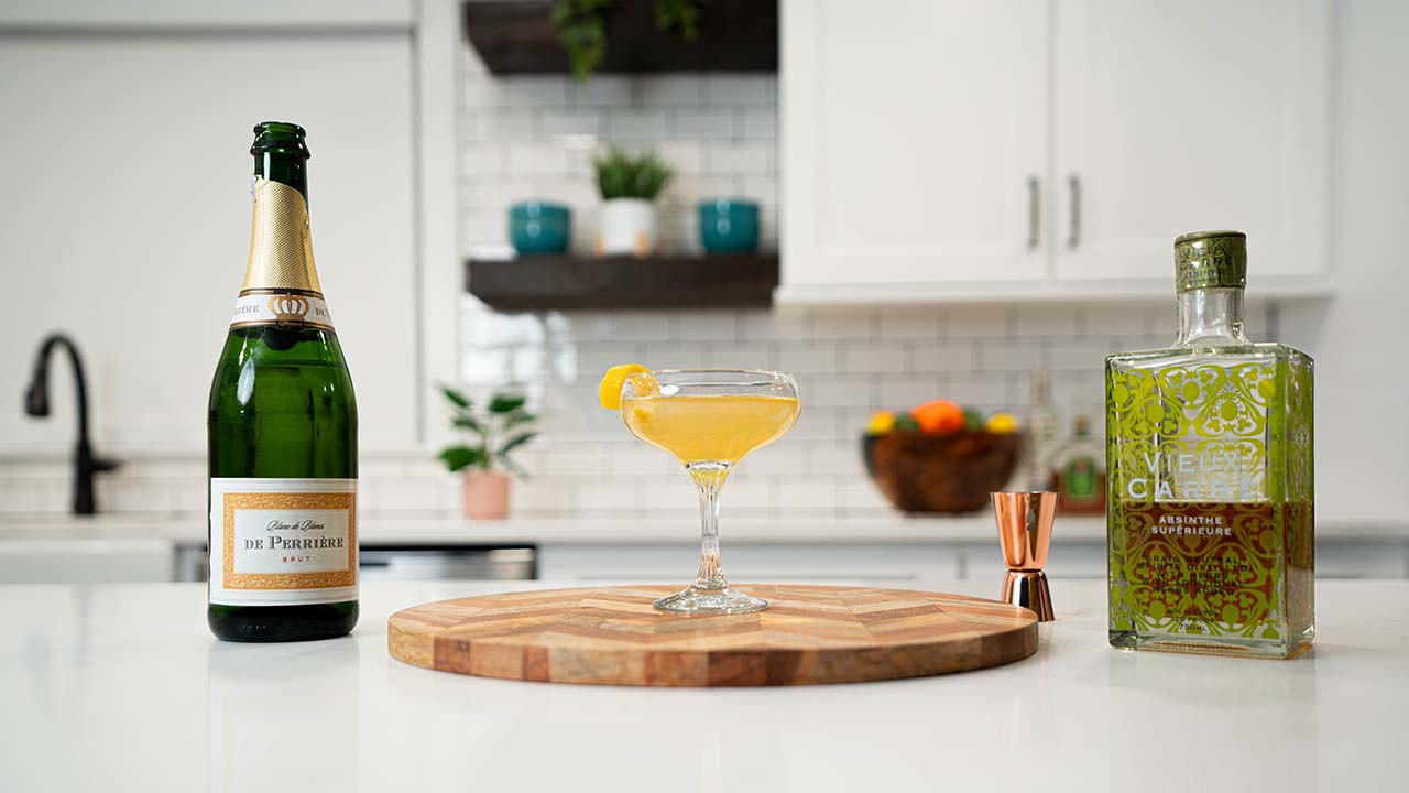 Death in the Afternoon cocktail with ingredients in the background